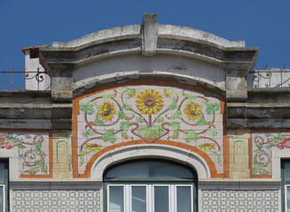 Streets of Lisbon. Detail of traditional Revival facade decorated with colorful flower tiles. Portugal. 