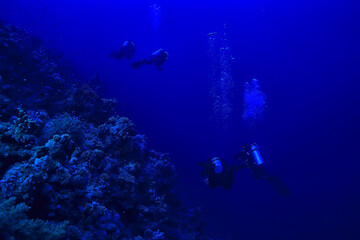 divers underwater at depth in the blue sea background