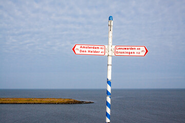 Signpost for cyclists along the Wadden Sea at the Afsluitdijk in the Netherlands