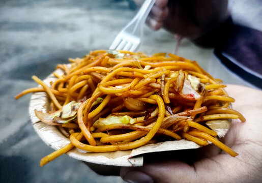 Asian Man Eating Noodle. Man Hands Holding Fork And Spoon During Eating Noodle