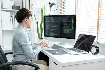 Male programmer is programming to develop program app and website of corporate while working to...