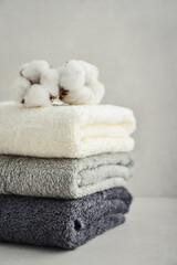 Fototapeta na wymiar Stack of bath towels with cotton flowers