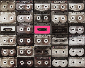 concept of standing out from the crowd,hot pink cassette on the background of an audio cassette, a...