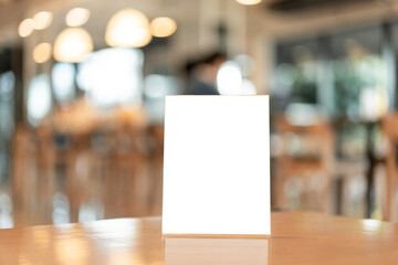 Menu frame with white blank screen on wooden table in restaurant or cafe on bokeh background