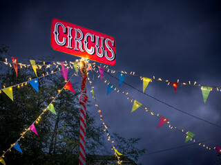 El circo iluminado y decorado con luces de colores y banderillas coloridas al llegar a la ciudad en...