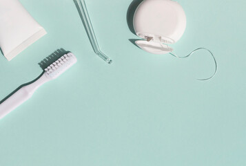 Dental care concept frame with toothbrush, irrigator, tooth floss and toothpaste on the blue...