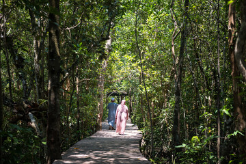 muslim couple walking along mangrove forest in Krabi