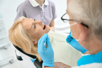 Caucasian pretty woman during the dental treatment in dental clinic