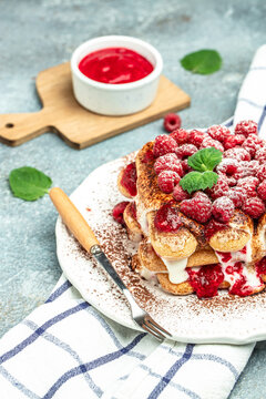 Summer dessert, classic tiramisu with raspberry decorated with mint leaves. vertical image. top view