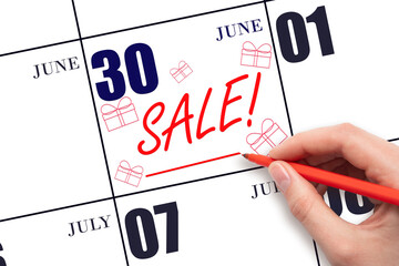 Hand writing text SALE and drawing gift boxes on calendar date June 30. Shopping Reminder