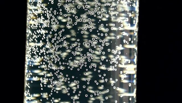 A glass of sparkling clean water on a black background. Aspirin dissolves in water. Small air bubbles in the water and on the walls of the glass. The medicine. Water for people on earth.