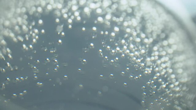 A glass of sparkling clean water on a black background. Aspirin dissolves in water. Small air bubbles in the water and on the walls of the glass. The medicine. Water for people on earth.