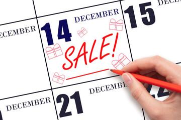 Hand writing text SALE and drawing gift boxes on calendar date December 14. Shopping Reminder