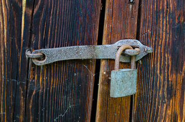 Lock on an old wooden door with rusty inserts