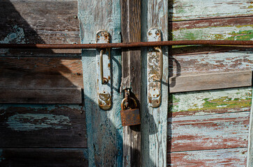 Lock on an old wooden door with rusty inserts