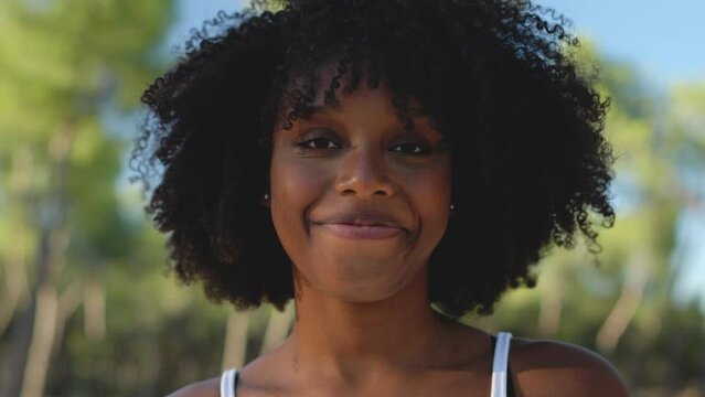 A woman with afro hairstyle smiling at the camera