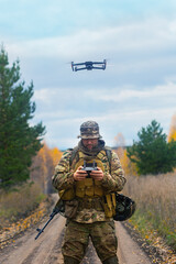The mercenary launches a reconnaissance drone. Vertical photo. - obrazy, fototapety, plakaty