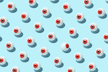 Eyeballs in the creative pattern on a pastel blue background. Individual opinion idea. 
