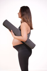 beautiful 30s-40s pregnant woman exercising with yoga matt