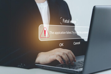 ฺBusinessman uses a laptop computer with fatal system notification with options. OK or cancel....