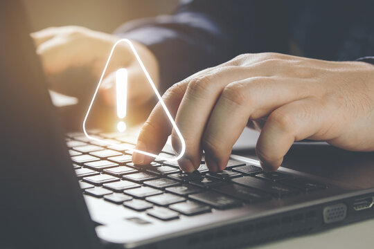 Businessman using laptop computer with alerts, warning triangles showing system errors. Concept of system maintenance, security, virus protection and hacking prevention accessing important information
