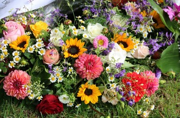 Bunte Blumen im Trauerkranz nach Beerdigung auf dem Friedhof
