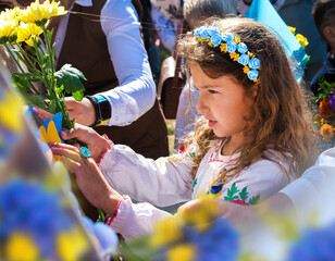 Ukrainian Schoolgirl in a wreath and embroidered shirt and with patriotic flowers against the war in Ukraine - 538407972