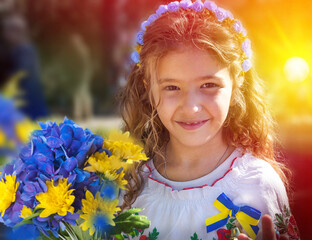 Ukrainian Schoolgirl in a wreath and embroidered shirt and with patriotic flowers against the war in Ukraine - 538408175
