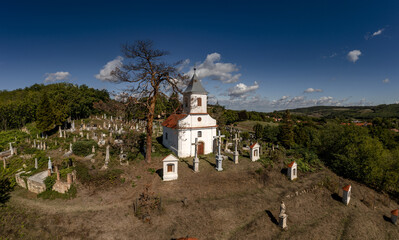 Small Christian chapel with graveyard on top of hill in Mecseknadasd, Baranya county, Hungary.