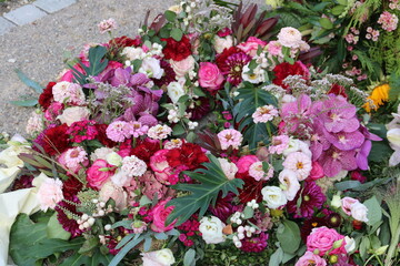 Trauerkranz mit bunten Blumen exotisch nach Beerdigung auf dem Friedhof in Rosa