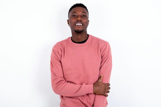 Young Handsome Man Wearing Pink Sweater Over White Background Laughing.