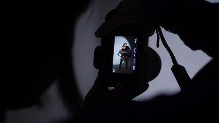 photographing a portrait of a beautiful sexy woman in the studio using a gabo mask and a white cyclorama. woman photographer on the silhouette takes pictures with a digital camera - Powered by Adobe