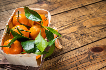 Fresh organic Tangerines, mandarins in wooden box from supermarket. Wooden background. Top view....