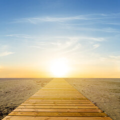 small wooden road on sandy beach to the sunset, natural summer vacation scene