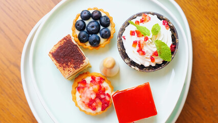 Top view of assortment of sweet food on plate in cafe