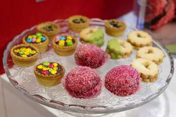 Chocolate, Shortbread, Red Sugar-coated Pastries Displayed above a Clear Plate