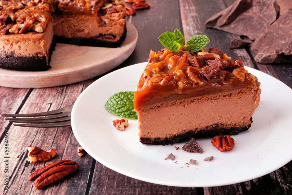 Poster slice of chocolate caramel pecan cheesecake. table scene close up with a dark rustic wood background