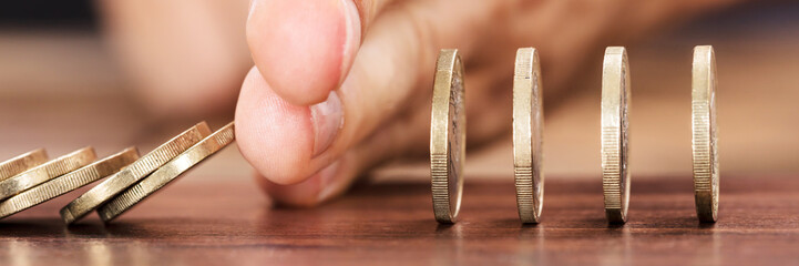 Hand Protecting Coins From Falling While Playing Domino