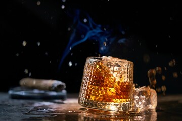 Glass of whiskey and smoking cigar on table. Copy space, black background. Whiskey, brandy, cognac,...