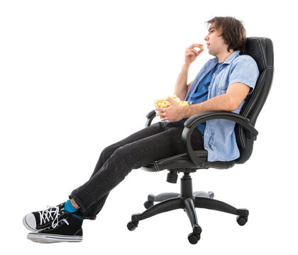 Lazy man sitting in armchair eating pop corn, isolated over white