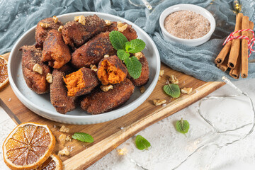 Traditional portuguese Christmas sweets named Bilharacos with sugar and cinnamon on kitchen countertop. This sweets are made with pumpkin. Is traditional in Aveiro region