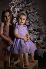 Child in smart clothes in front of the Christmas tree. Waiting for the new year.