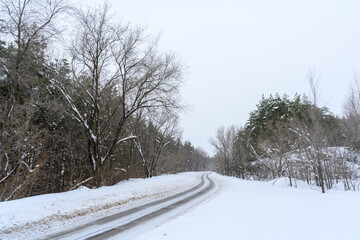 Obraz premium Snowy winter road in a mountain forest.