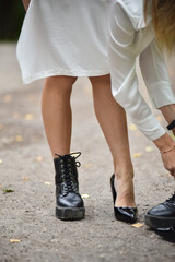 Young woman on the street changing shoes