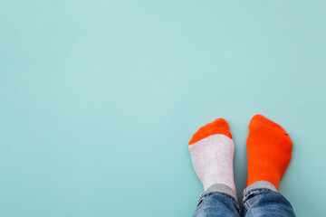 Odd socks day concept. Legs in different socks on a blue background. Top view.