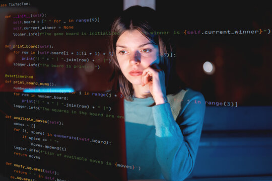 Girl works on a laptop at night, coding and creating project.
