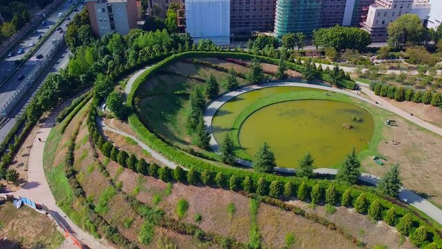 Aerial view of the modern architecture of residential buildings and parks in the new districts of the city. Pedestrian bridge over the highway. Cars on the road. Skyline. Milan, Italy