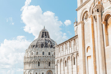 Beautiful vintage architecture on a blue cloudy sky in an ancient European town. Travelling in Pisa, Italy. Beautiful facade of a cathedral