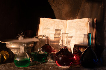 Smoking cauldron, magic potions and ancient spell book