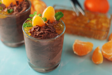 Chocolate mousse dessert with tangerines in glasses